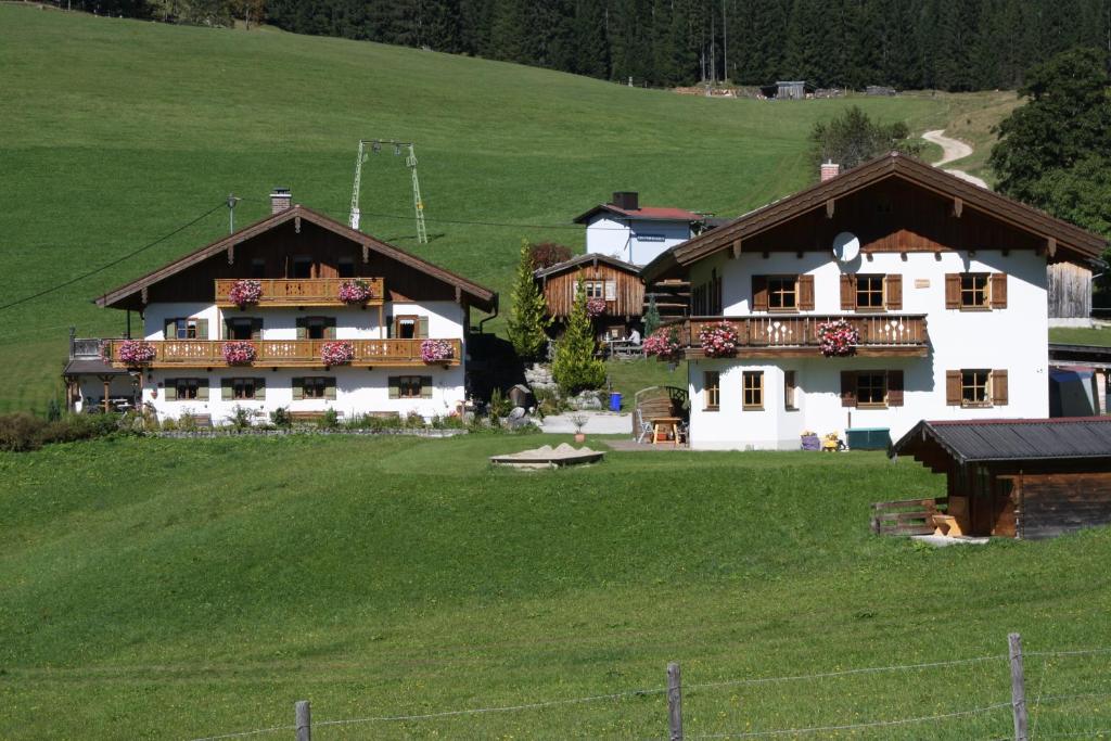 ein großes Haus auf einem Hügel mit grünem Feld in der Unterkunft Fronwieshäusl Gschoßmann Herbert in Ramsau bei Berchtesgaden