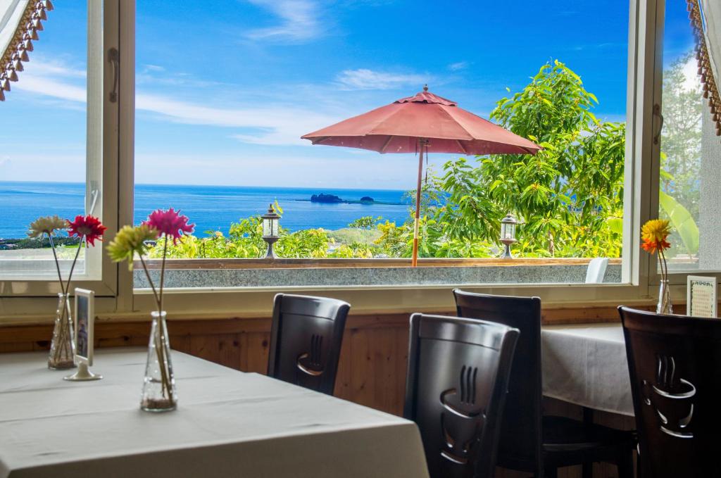 a restaurant with tables and chairs and a view of the ocean at Sansendai Sea View B&amp;B in Chenggong