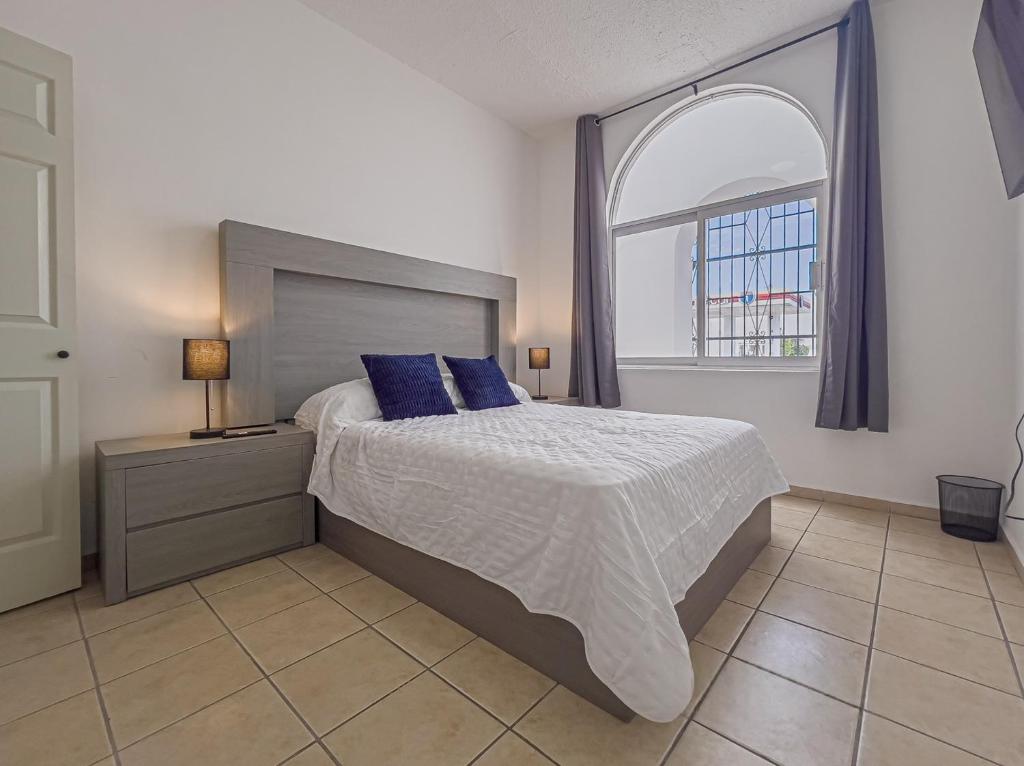 une chambre avec un lit avec des oreillers bleus et une fenêtre dans l'établissement Casa Balandra 2BR home downtown LPZ walk everywhere, à La Paz