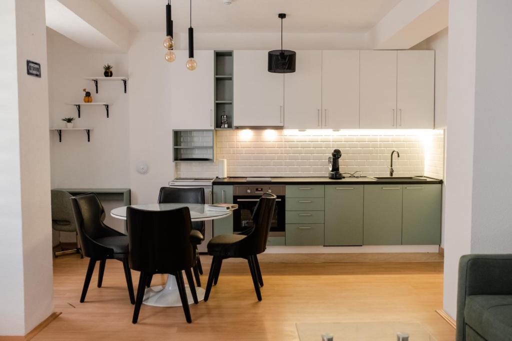 オフリドにあるLihnidos Home, Neer Lake Apartment, ACのテーブルと椅子のあるキッチンとダイニングルーム