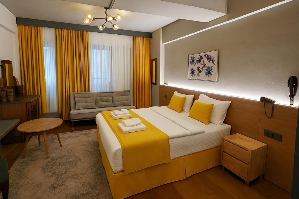 a hotel room with a large bed and a chair at Aleksandr Pera Hotel in Istanbul