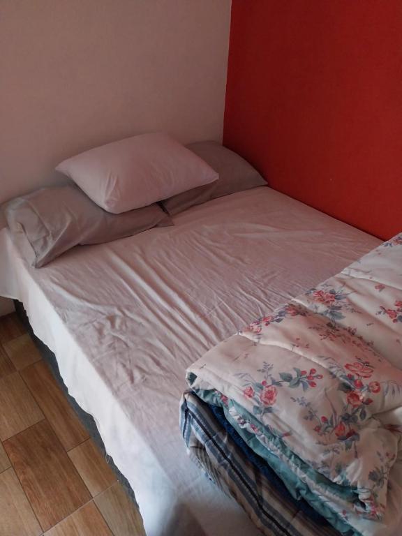 a unmade bed with a pillow and blanket on it at Casa para alugar in Paraty