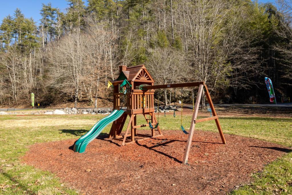 ein Spielplatz mit Rutsche in einem Park in der Unterkunft Skyfall Lodge by American Patriot Getaways in Park Settlement