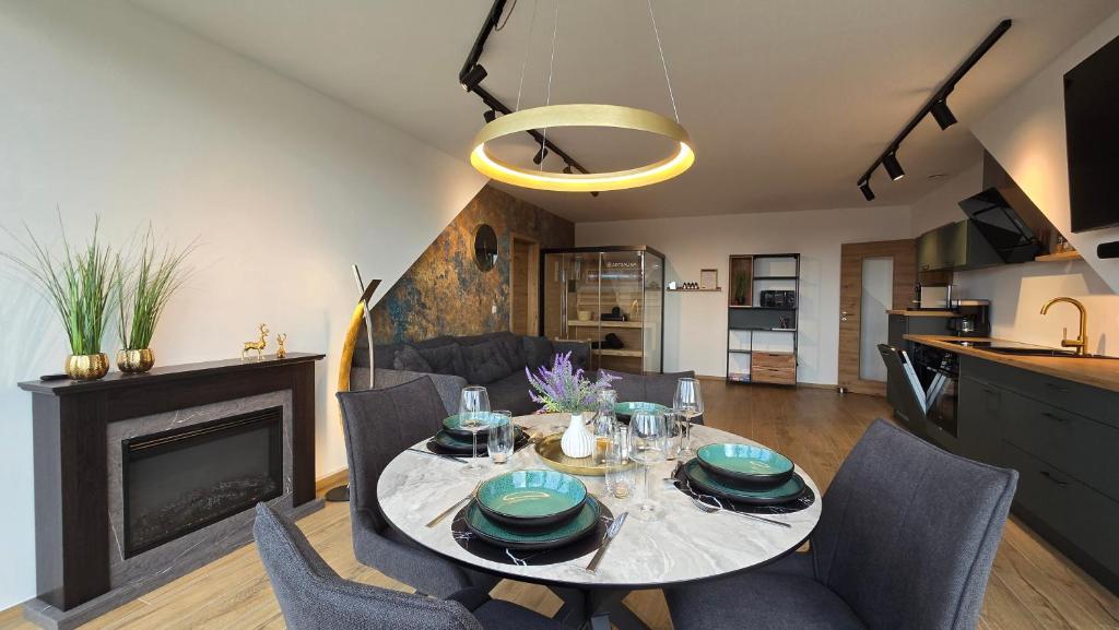 a dining room with a table with chairs and a fireplace at Luxus Ferienwohnung Himmel und SPA mit privater Sauna und Wellnessdusche inkl Wifi und Parkplatz für 4Personen in Muhr amSee