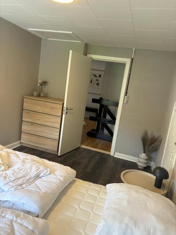 1 dormitorio con 1 cama y una puerta que conduce a una mesa en Hvidbo, en Vordingborg