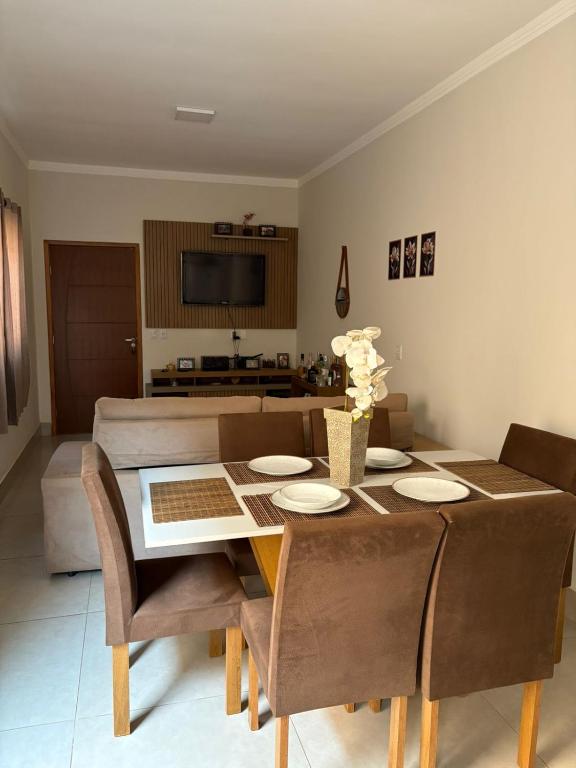 a dining room with a table and chairs and a couch at Temporada Barretos 2025 in Barretos