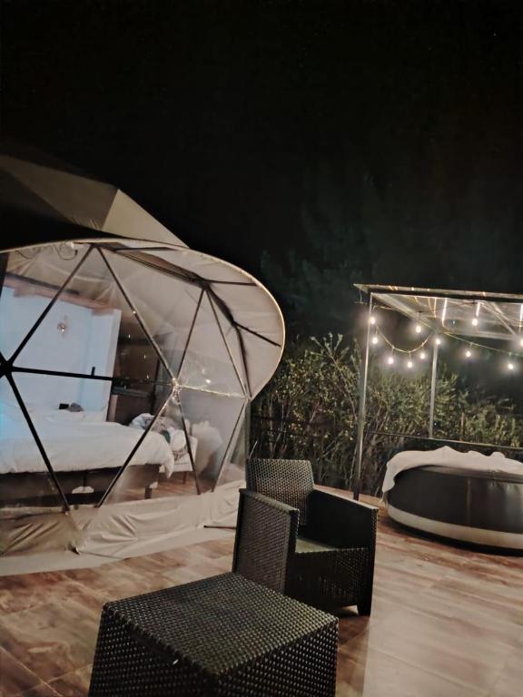 a tent with a chair and a bed with lights at Sweet Forest- Domo Luna in Punilla