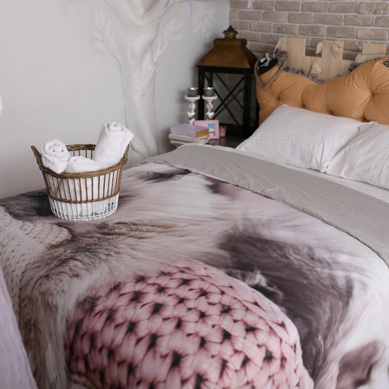 a bed with a blanket and a basket of towels on it at Апартаменти Studio Amur Creative in Khmelnytskyi