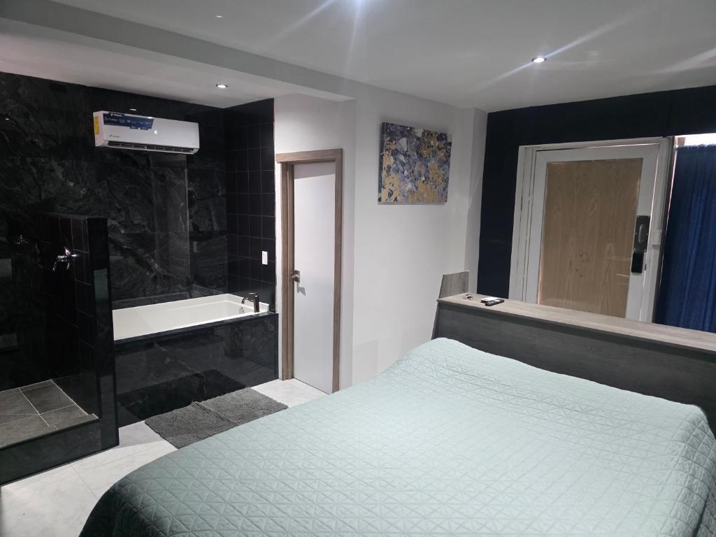 La CoyoteraにあるCataleya Suites Cassandraのベッドルーム(ベッド1台、バスタブ付)