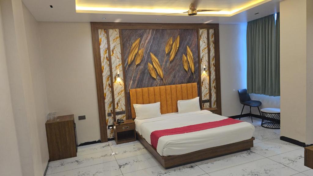 a bedroom with a bed with a painting on the wall at Premvakita restaurant and hotel in Ratlām