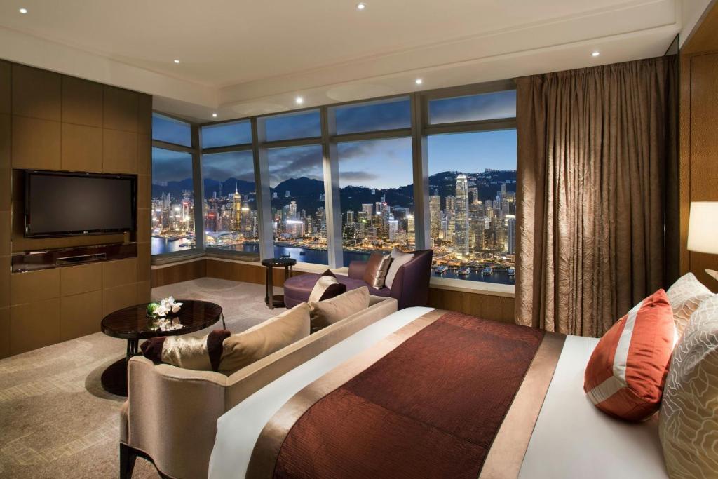 a hotel room with a large bed and a large window at The Ritz-Carlton, Hong Kong in Hong Kong