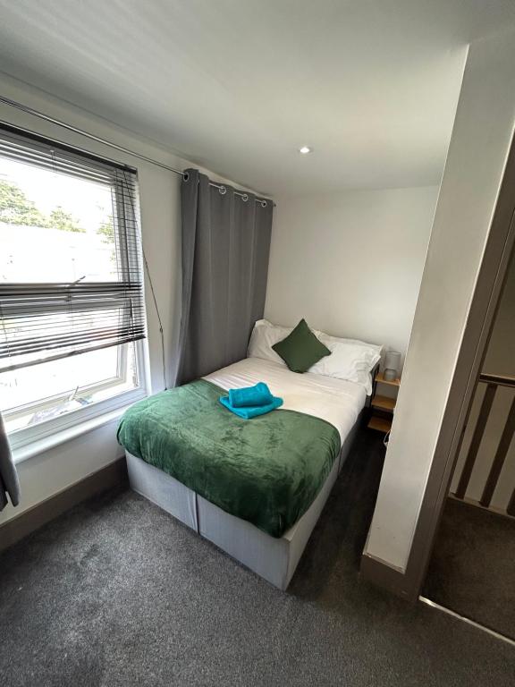 a small bedroom with a bed and a window at Saunders Lodge 4bedroom house sleeps up to 6 in Gillingham