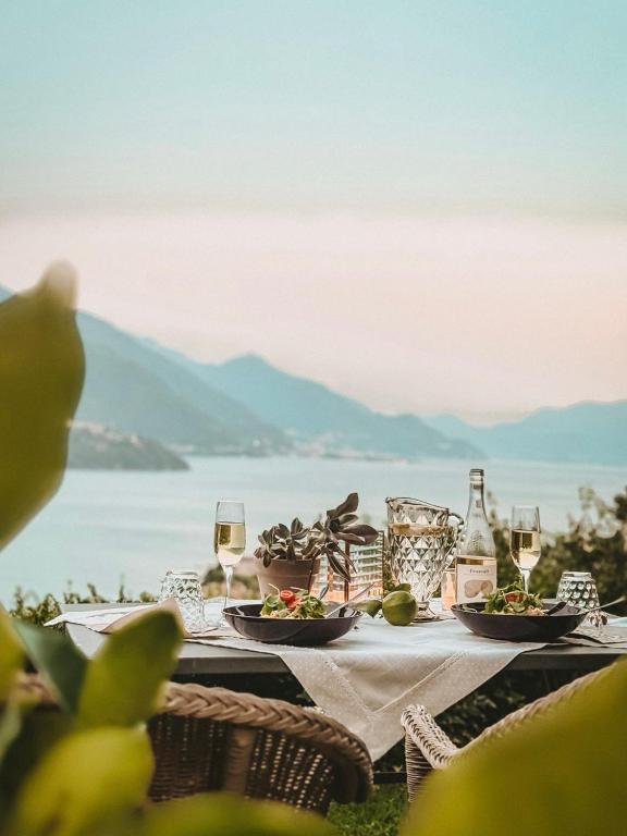 a table with plates of food and wine glasses at La Rondine in Gravedona