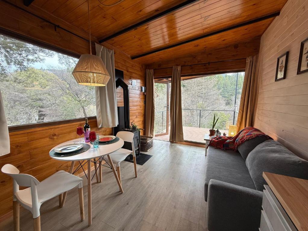 una sala de estar con una mesa y un sofá en RIO-ABAJO Cabañas frente al RIO MELIQUINA, en Villa Meliquina