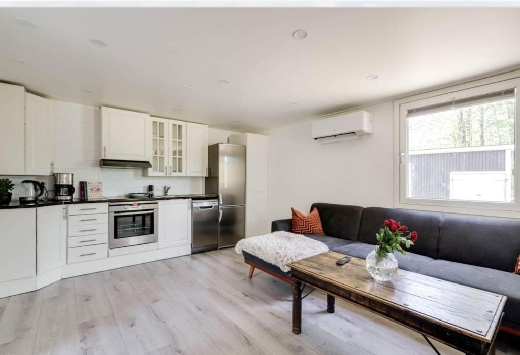 a living room with a couch and a table at Summer cottage near water with boat for rent in Åsbro