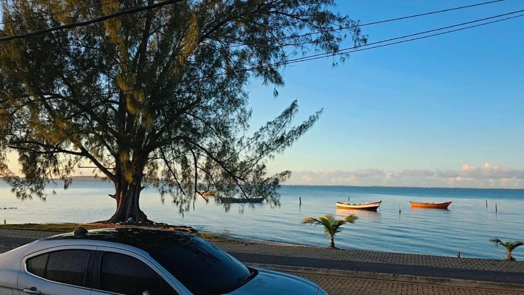 a car parked next to a body of water with boats at Pousada Casa Del Mare in São Pedro da Aldeia