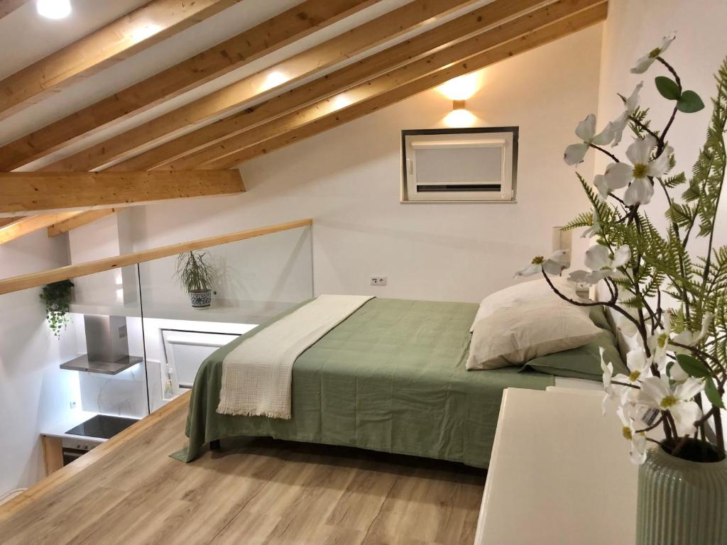 Un dormitorio con una cama verde en una habitación. en Zeca Holidays -Atalaia Fall Mezanine Ideal para trabalhar, en Lourinhã