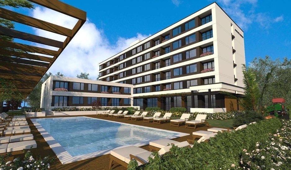 a hotel with a swimming pool and chairs and a building at Domenico Luxury Apartments in Sunny Beach