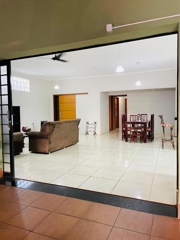 a living room with a couch and a dining room at Casa Coqueiros in Barretos