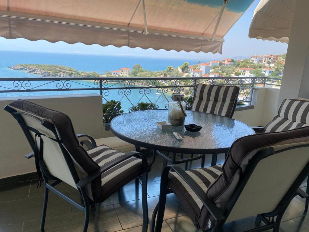 a table and chairs on a balcony with a view of the ocean at Villa Seaside View Complex with pool in Volos