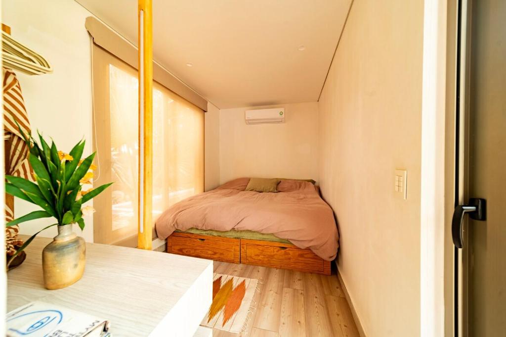 La MajahuaMinimalist Surf, Pool, AC, Icebath, Yoga, Saladita, 50m to Surf的小房间的小卧室配有床