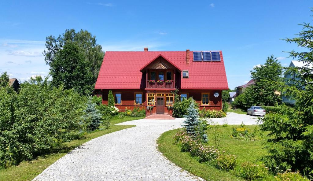 une maison au toit rouge avec une allée en gravier dans l'établissement Wiśniowy Sad, à Białowieża