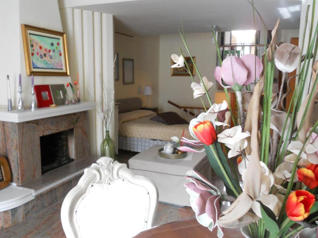 una sala de estar con chimenea y un jarrón de flores en Sweet Sweet Home en Tolve