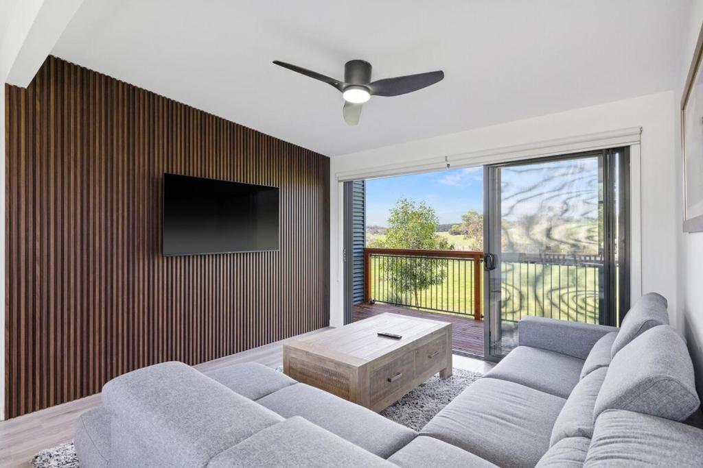 Una sala de estar con un sofá y un televisor de pantalla plana. en Luxury Hills Villa Retreat Phillip Island Resort, en Cowes