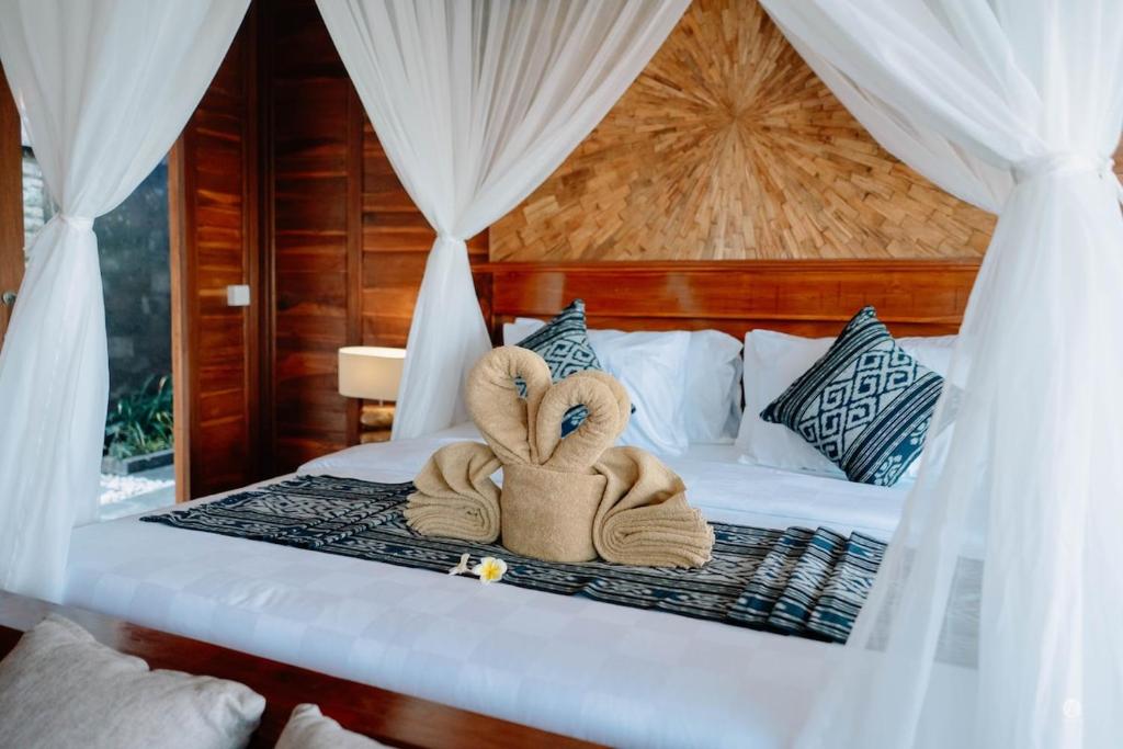 Dos toallas encima de una cama. en Uma Sunset Villa, en Ubud