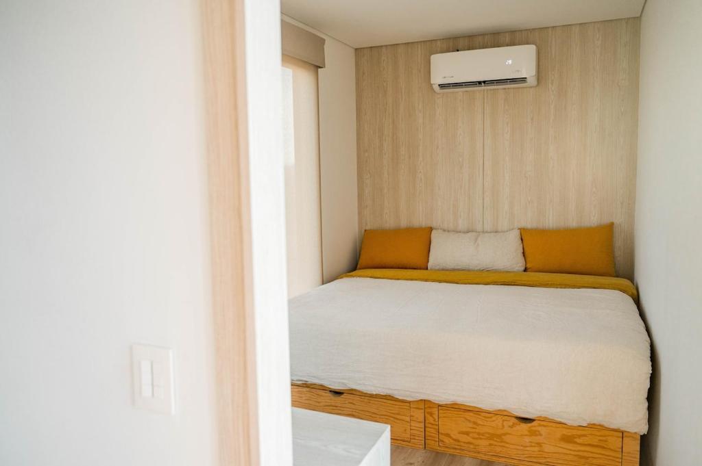 a small bedroom with a bed in a room at Surf Retreat La Saladita, Yoga, Pool, Templo, Casita Sol in La Majahua