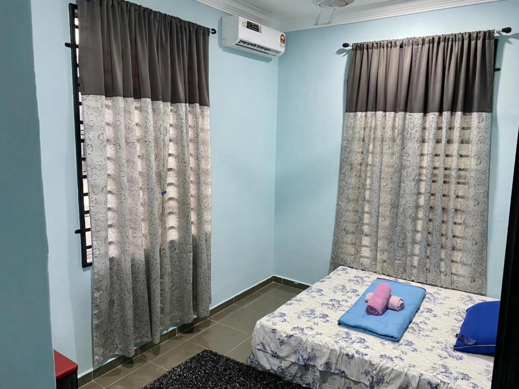 a bedroom with a bed with a pink doll on a pillow at Habib Homestay in Kuala Terengganu