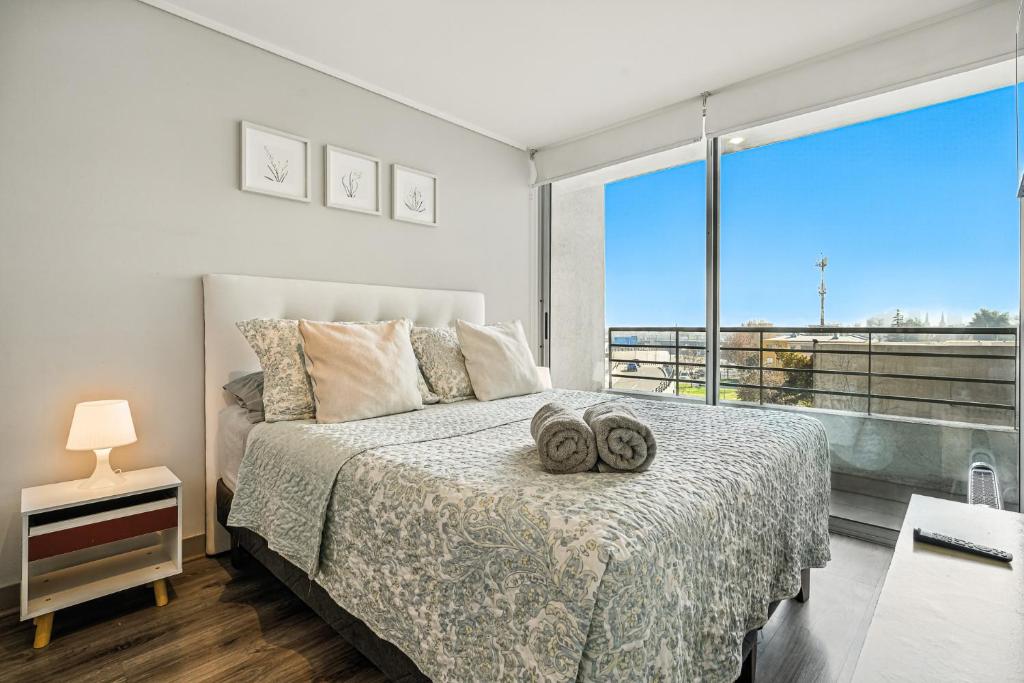 a bedroom with a bed and a large window at Apartamento General Mackenna B&E in Santiago