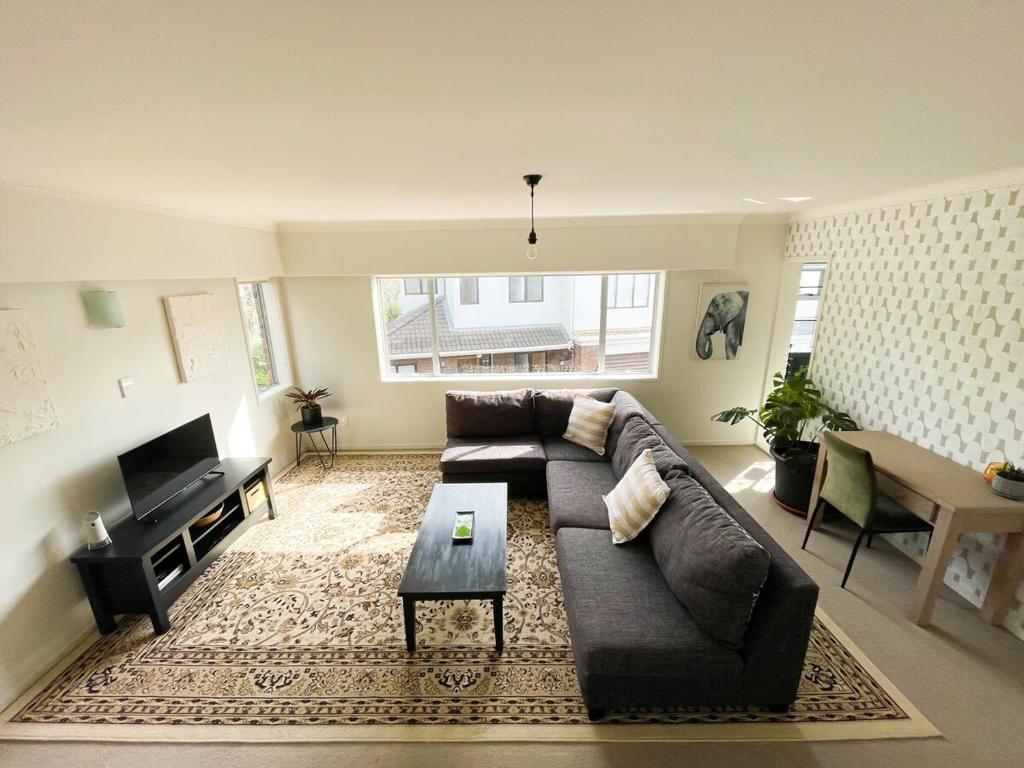 a living room with a couch and a table at Kohi Beach Hideaway in Auckland