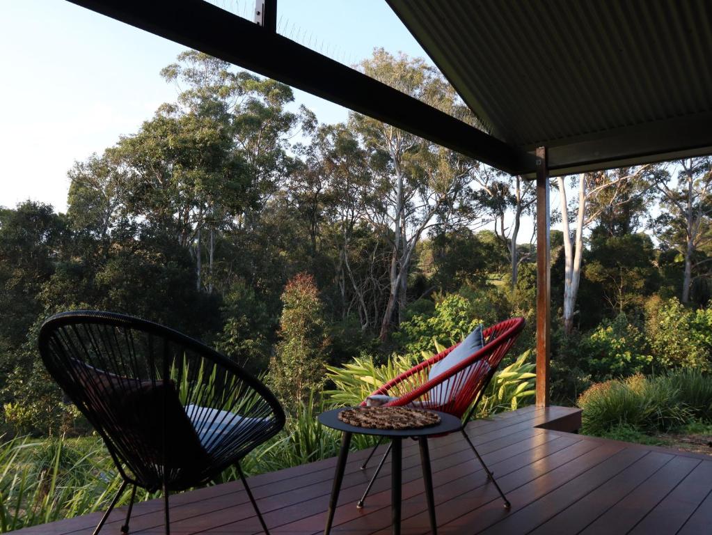 due sedie e un tavolo su un ponte di legno di Hideaway Falls - Bunya Cottage a Mapleton