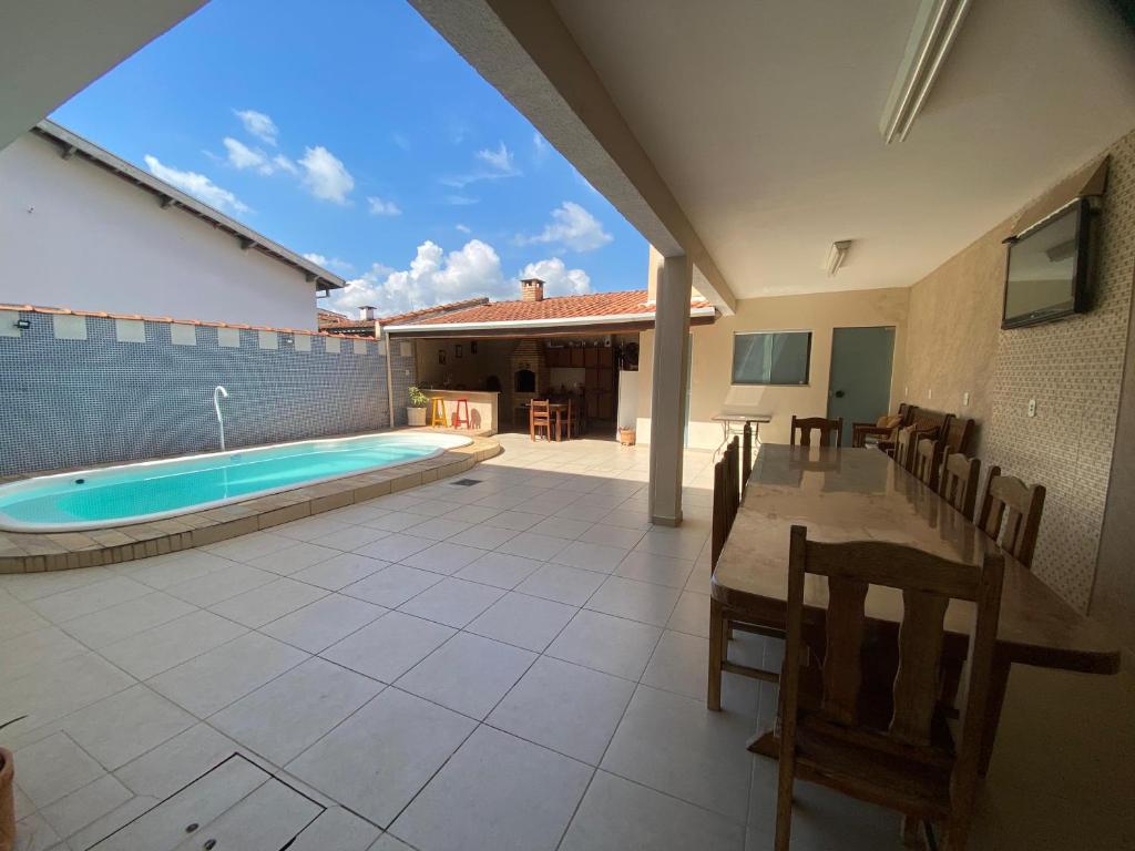 a patio with a table and a swimming pool at Casa em Guaratinguetá-Casa da Rosa in Guaratinguetá