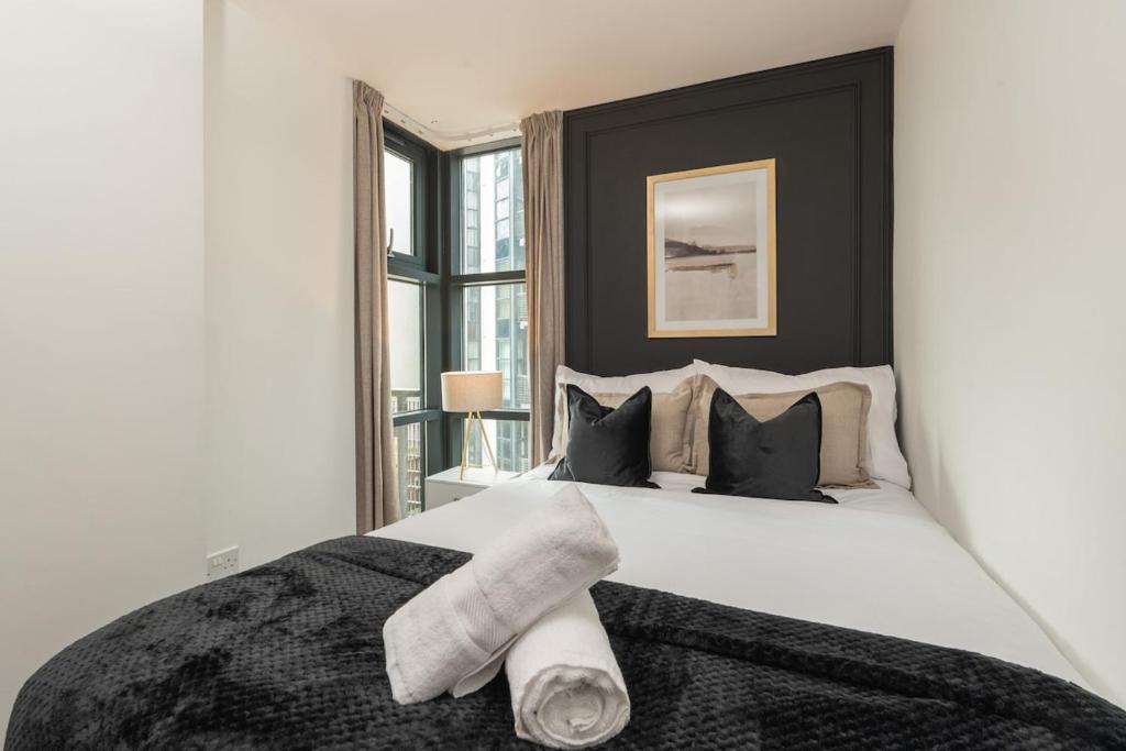 a bedroom with a large white bed with black pillows at Luxury Liverpool City Centre Apartment with Balcony, Sleeps 8, Near Liverpool ONE and Royal Albert Docks in Liverpool