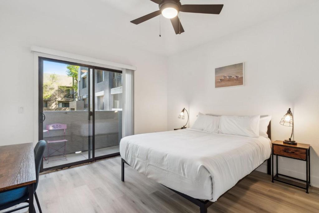 ein Schlafzimmer mit einem Bett und einem Deckenventilator in der Unterkunft CozySuites in Glendale Westgate with pool #07 in Glendale