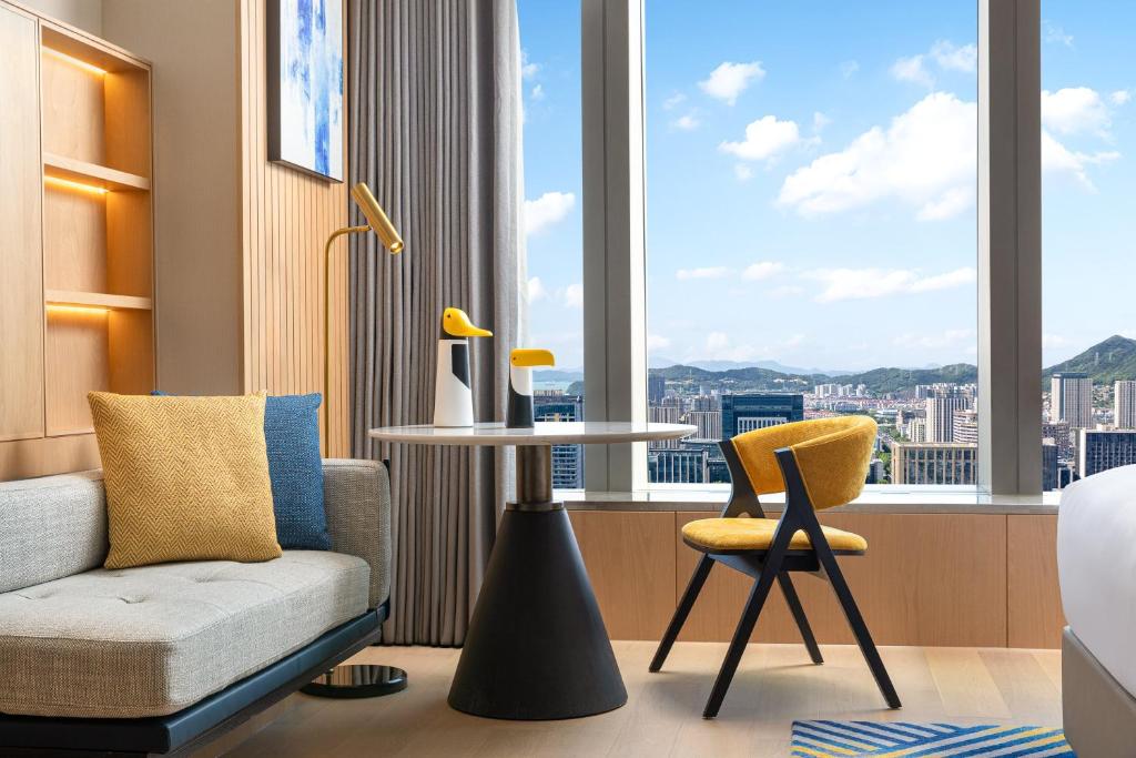 a hotel room with a couch and a table and a window at voco Zhoushan Putuo by IHG in Zhoushan