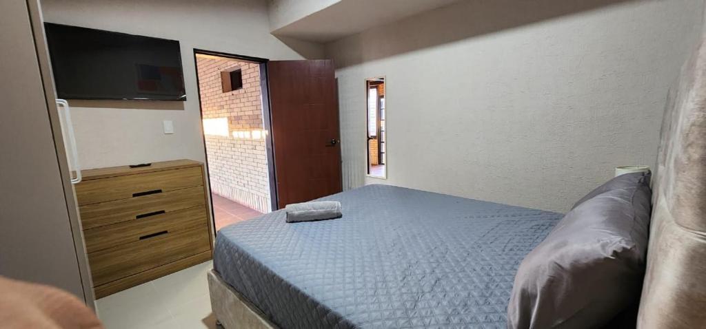 ein kleines Schlafzimmer mit einem Bett und einem Fernseher in der Unterkunft Hermosa y Elegante casa en Alto Barinas en alquiler in Barinas