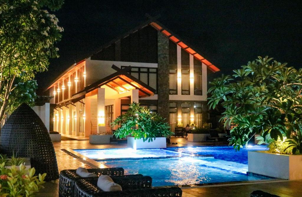 a swimming pool in front of a house at night at Urban Chic Home Urban Chic Home with balcony in Pajo