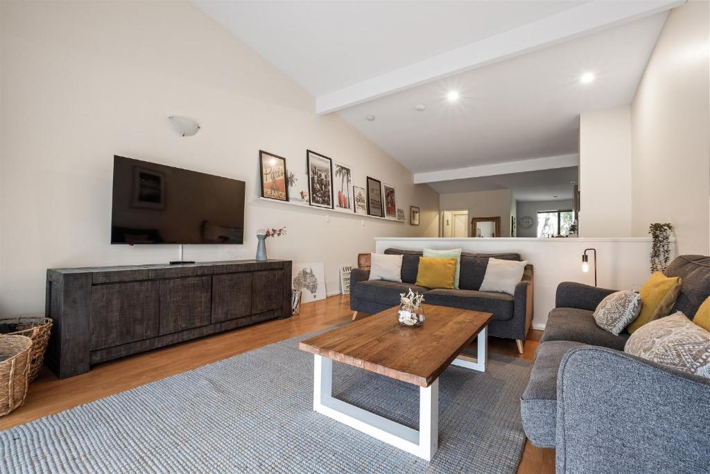 Una sala de estar con un sofá y un televisor. en TreeTops Margaret River, en Margaret River Town