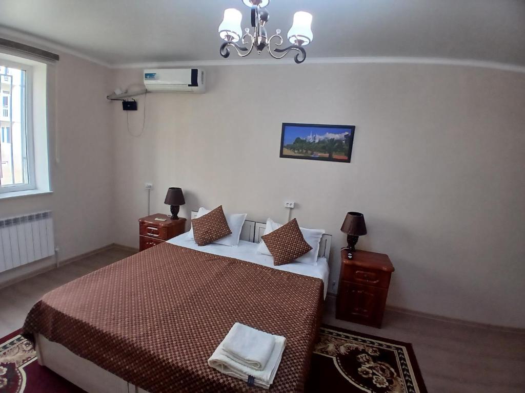 Un dormitorio con dos camas y una lámpara de araña. en Full apartment in city center, en Khiva