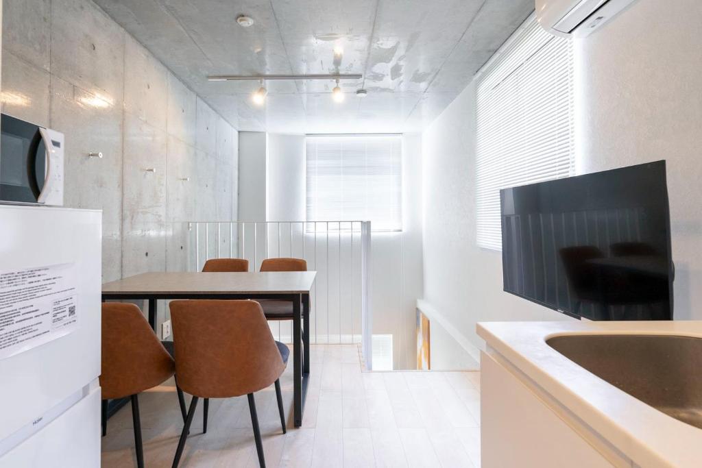 a kitchen with a table with chairs and a television at PASEO ichigayadaimachi I in Tokyo