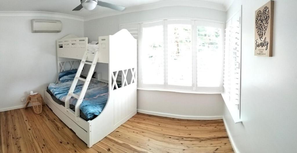 a bedroom with two bunk beds and a window at Family Beach House with Swim Spa in Nelson Bay