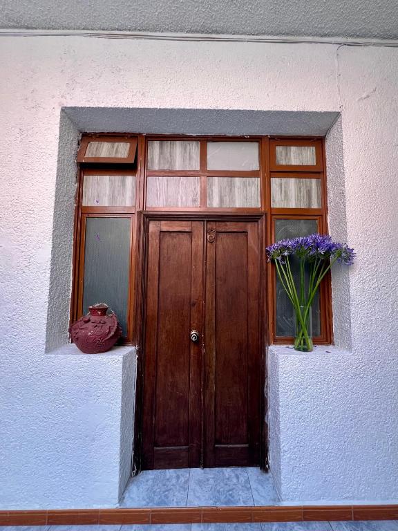 a wooden door with a window and a vase of flowers at Marqués 100 Exmarquesado in Oaxaca City