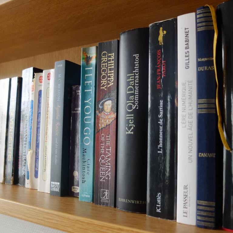 a row of books on a book shelf at B&B HOTEL La Rochelle Centre in La Rochelle