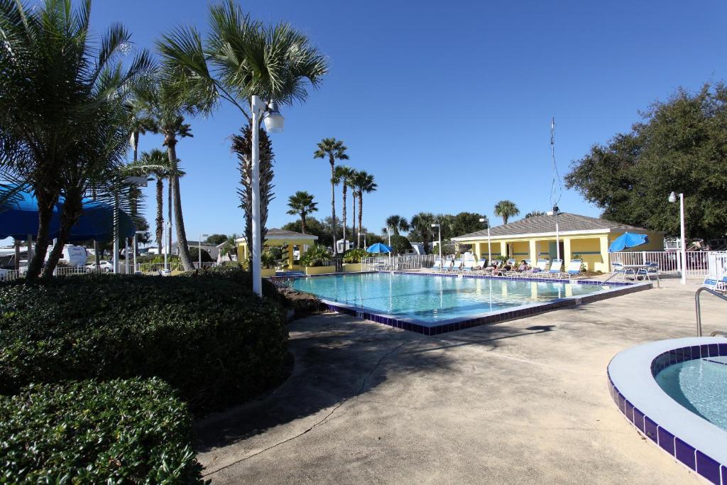 a swimming pool with palm trees and a resort at Lake Magic Cottage 1 in Kissimmee