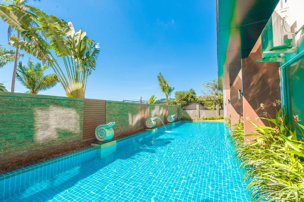 a swimming pool in the side of a building at Karon Chic Studio in Karon Beach