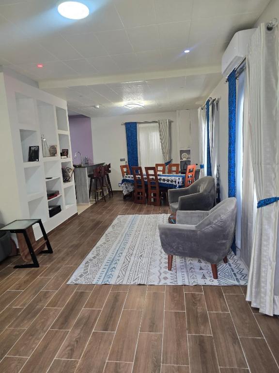 a living room with a couch and a chair at Le Champ des Roseaux - Kotto Douala in Douala