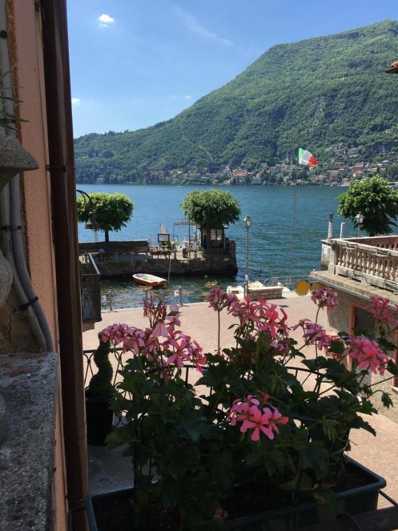 a view of the water from a window with flowers at Bed & Breakfast Dèco in Torno